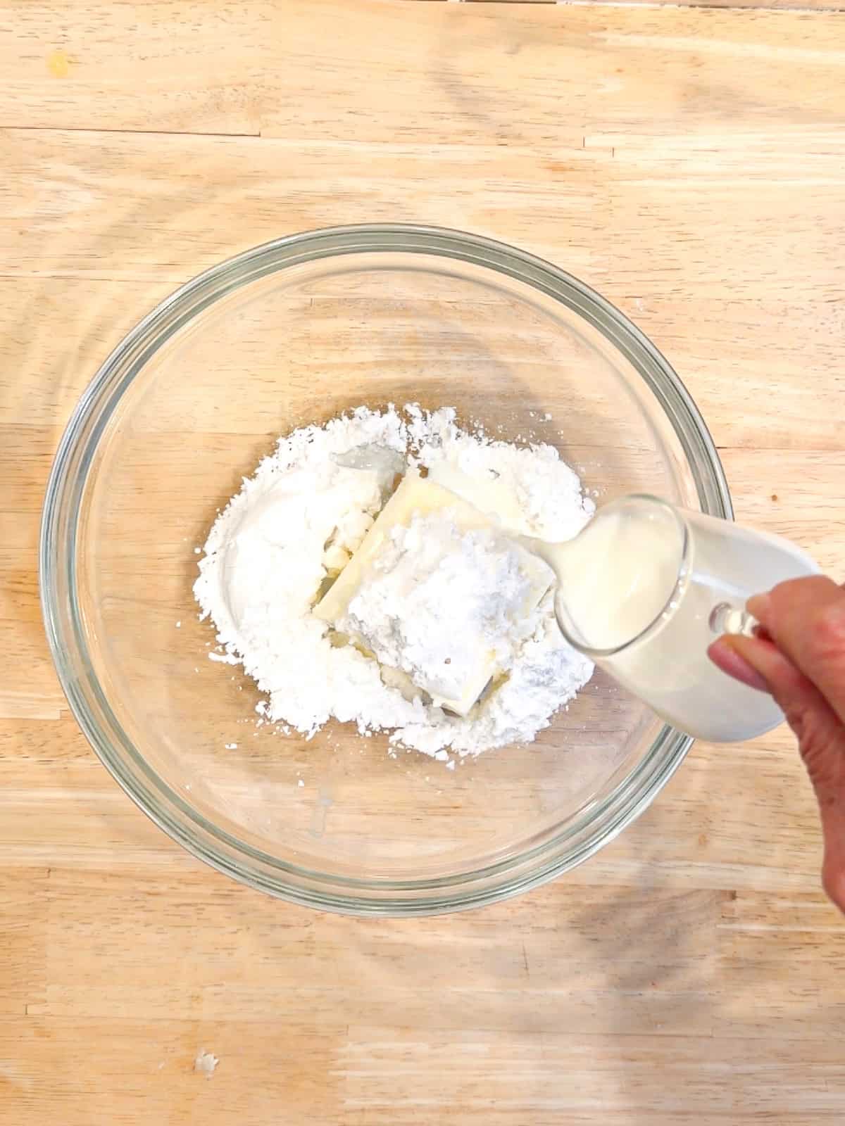 Ingredients for cream cheese icing in a glass bowl.