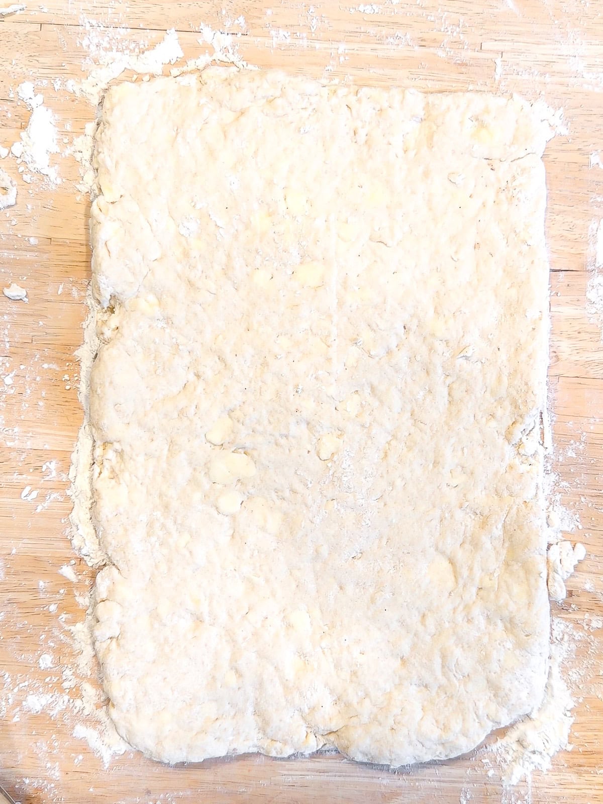Biscuit dough rolled out into a large rectangle.