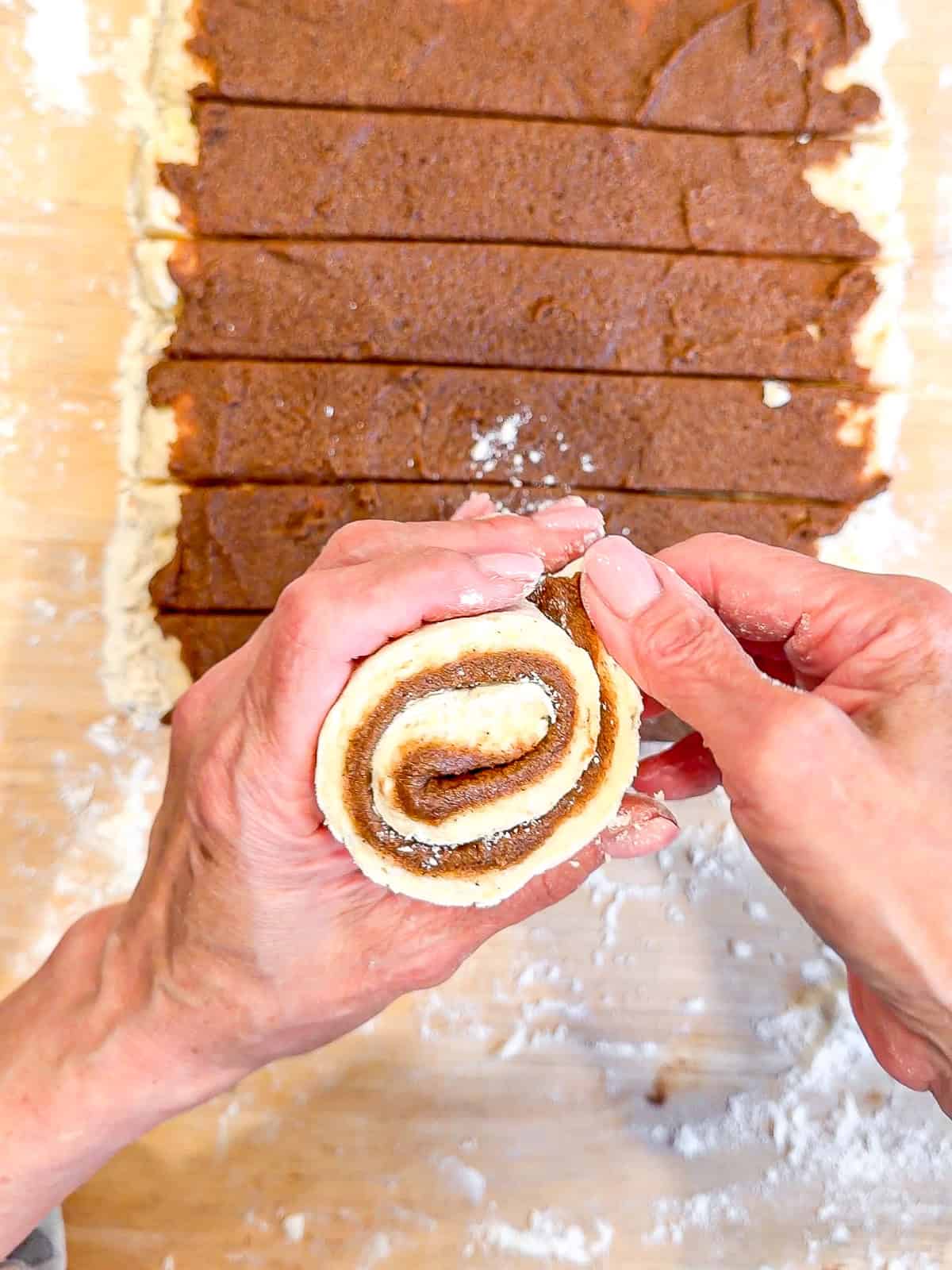 Tucking the end of a cinnamon roll underneath itself.