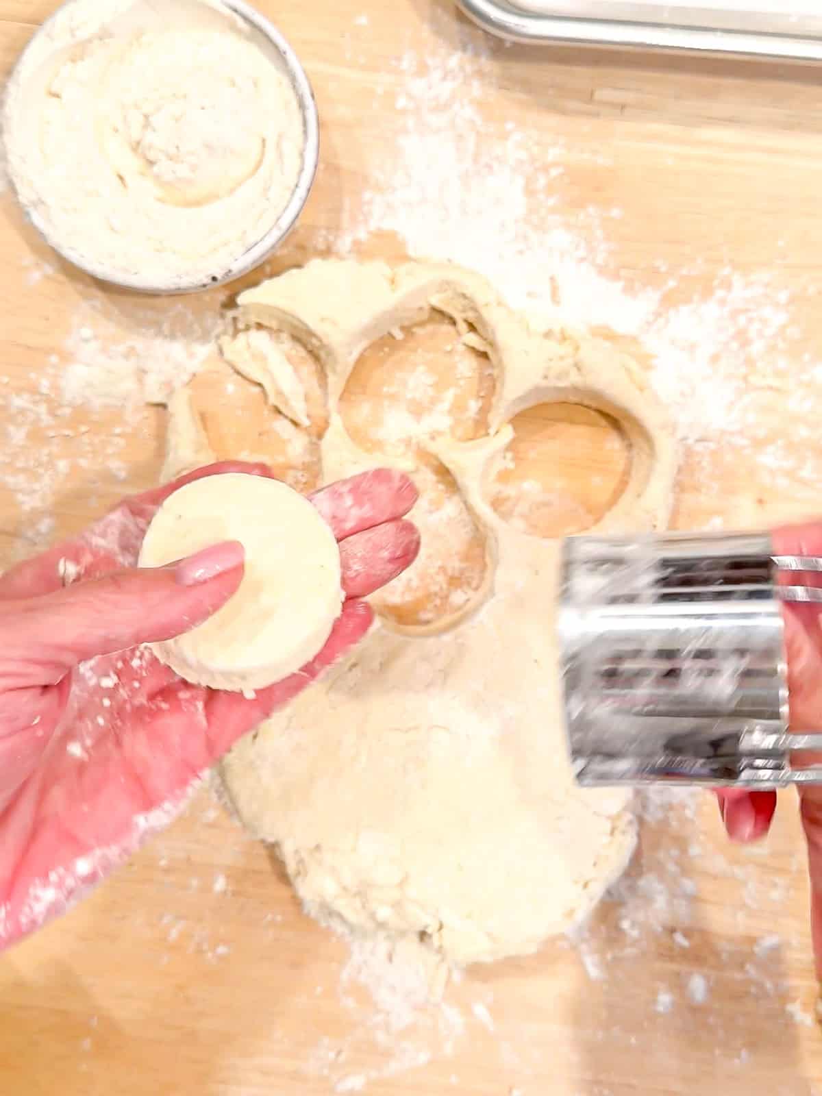 Cutting out biscuits on a wooden cutting board.