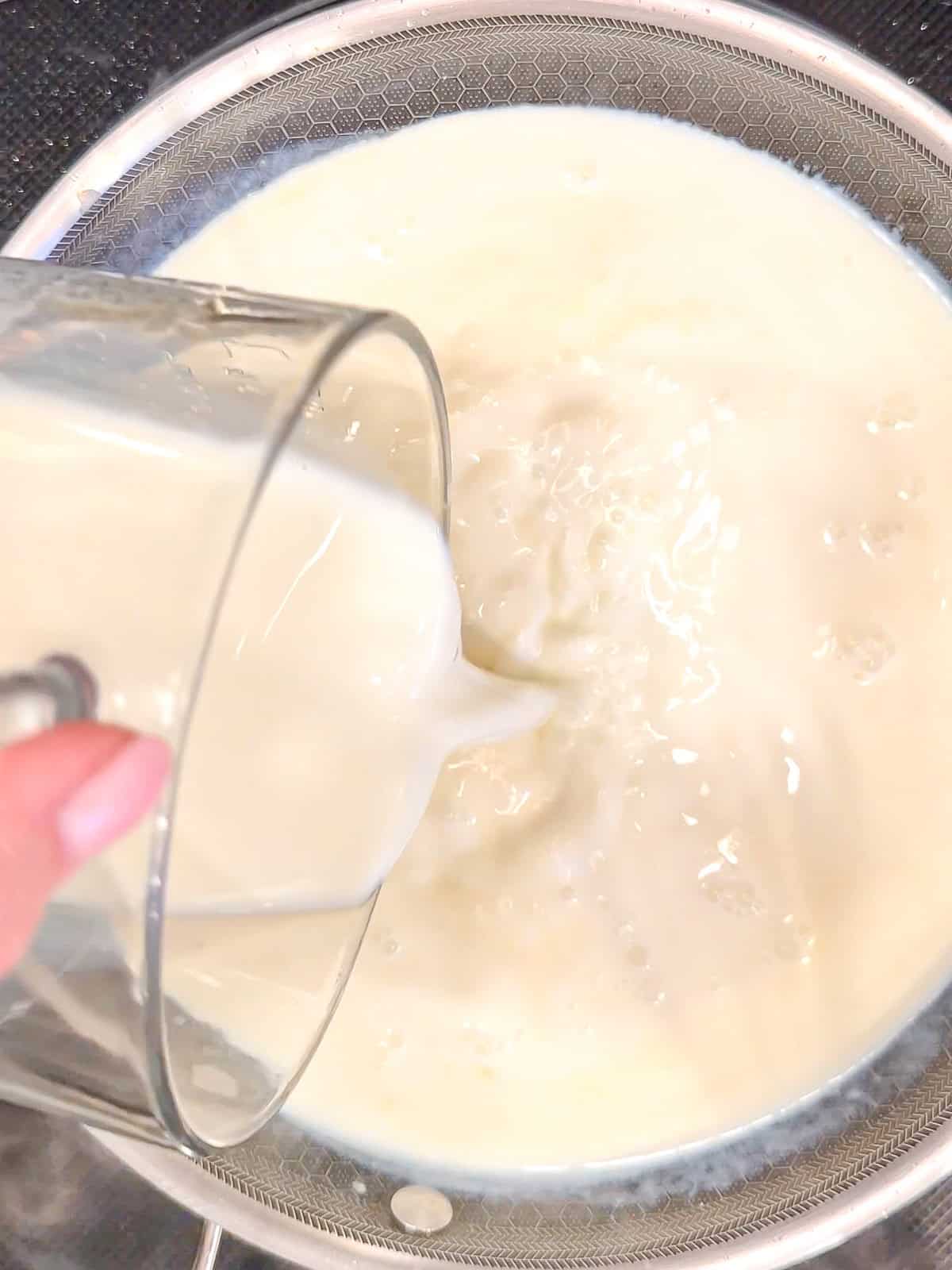 Pouring milk into a pan to make gravy.