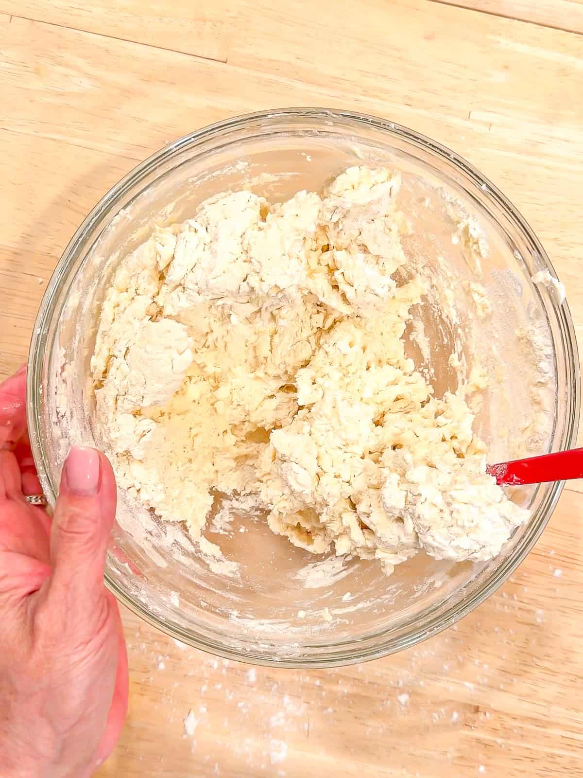 Biscuit dough in a glass bowl.