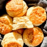 A basket of biscuits, one with butter in the middle.
