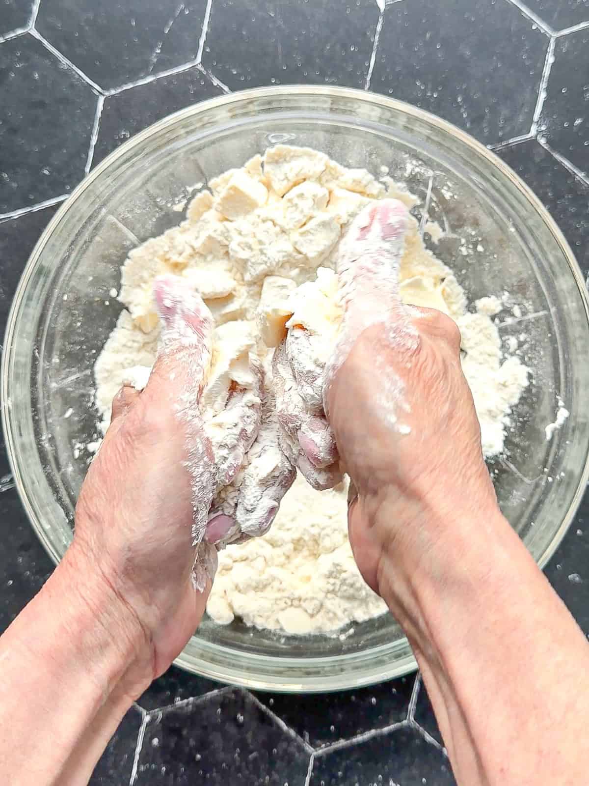 Cutting butter into the flour mixture to make biscuits.