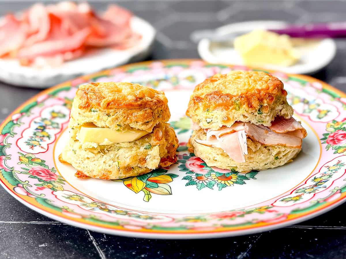 Two Greer biscuits on a floral plate, one with butter, one with ham.