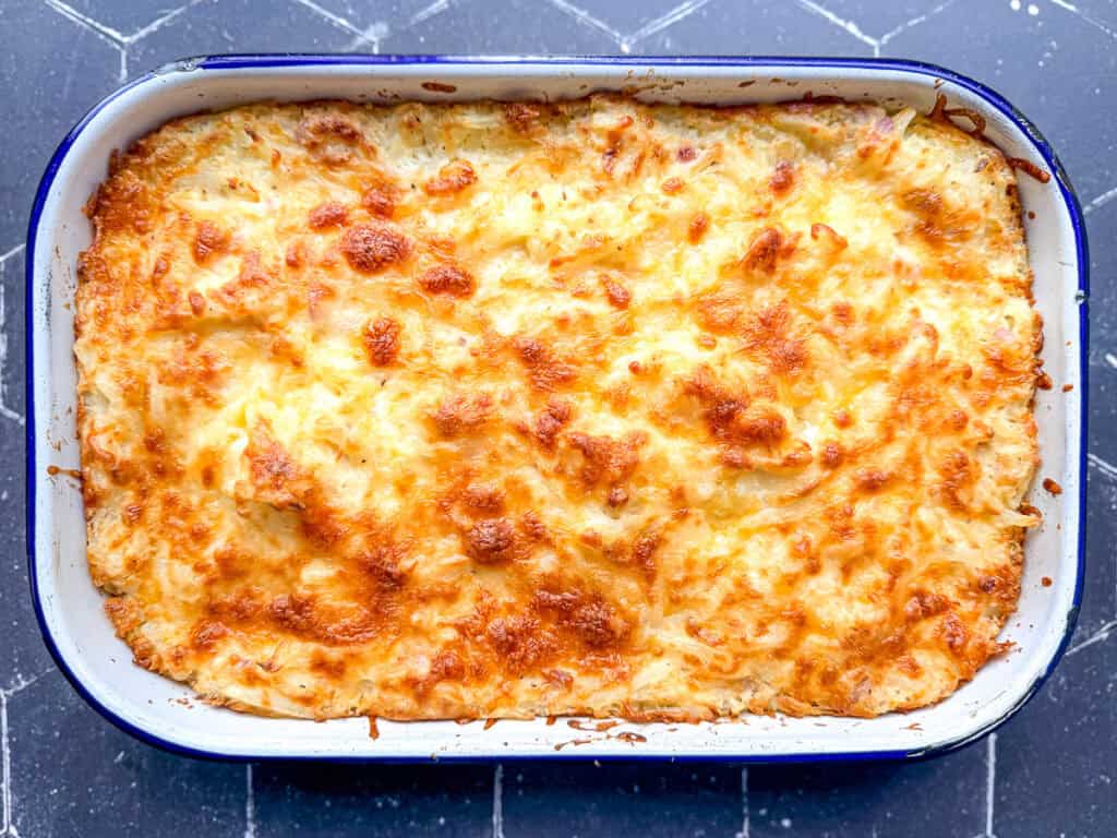 Hash brown casserole in a white enamel pan.