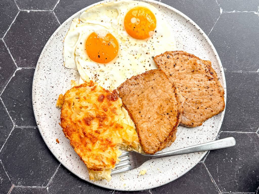 Hash brown casserole with pork chops and eggs.