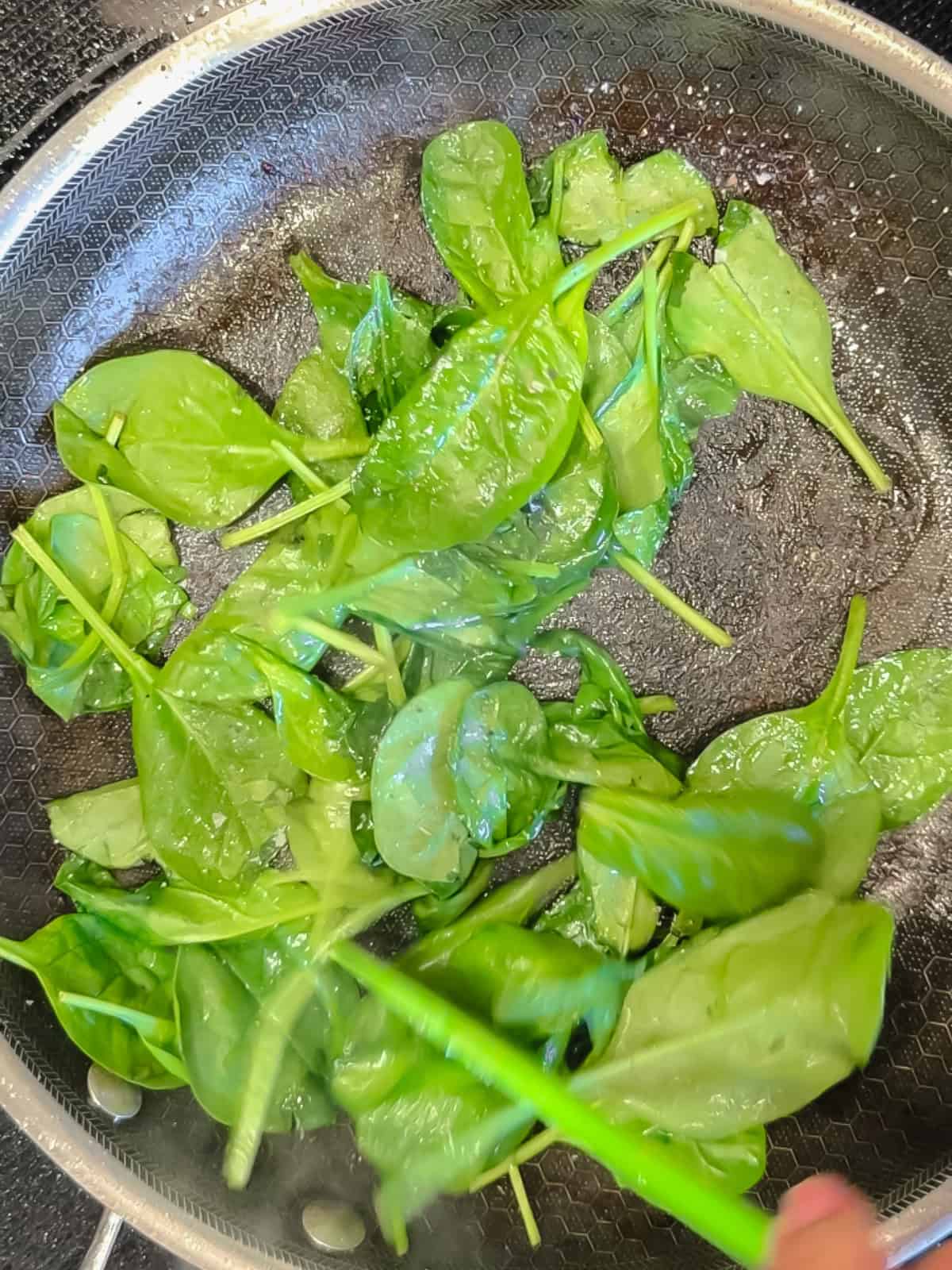 Sautéing spinach leaves.
