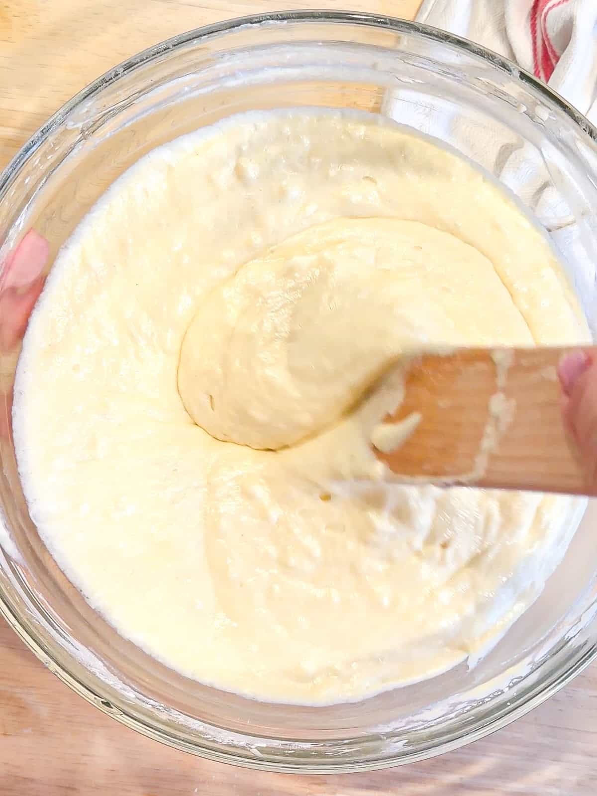 Mixing waffle batter with a wooden spatula.