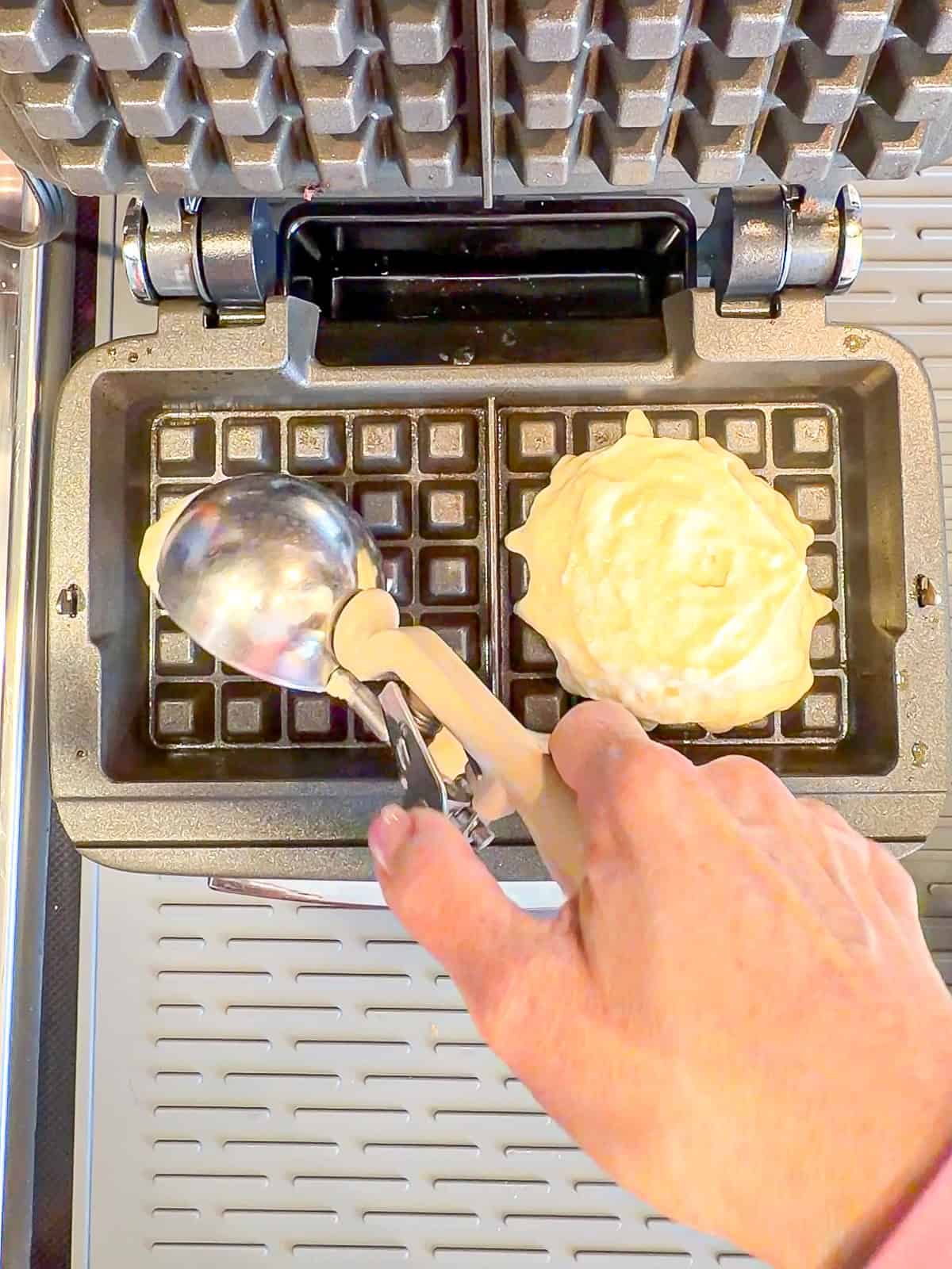 Scooping waffle batter into a waffle maker.