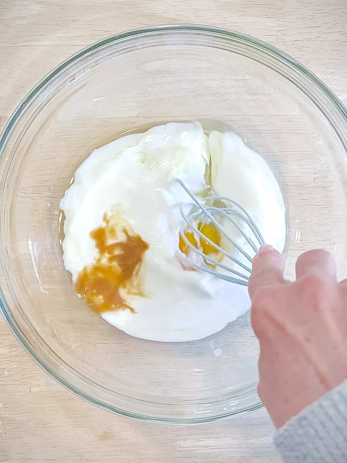 Whisking wet ingredients to make waffle batter.