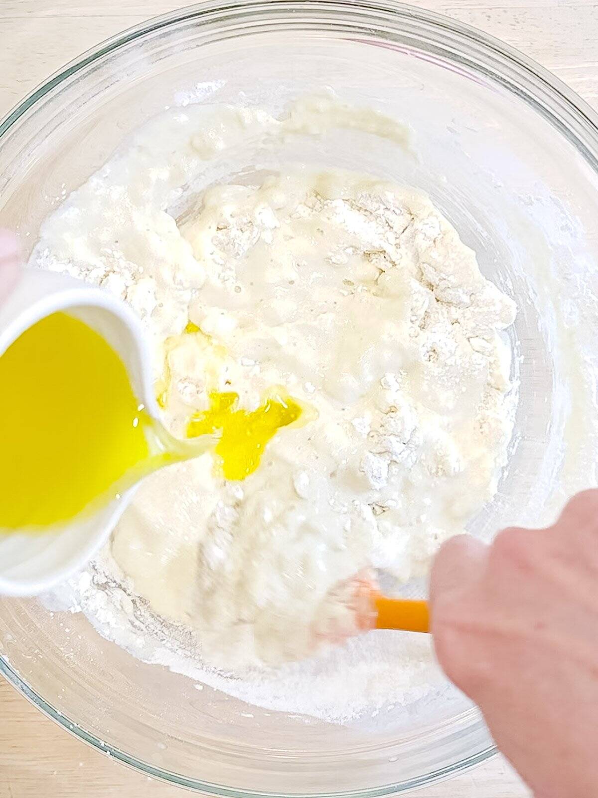 Adding melted and cooled butter to waffle batter.