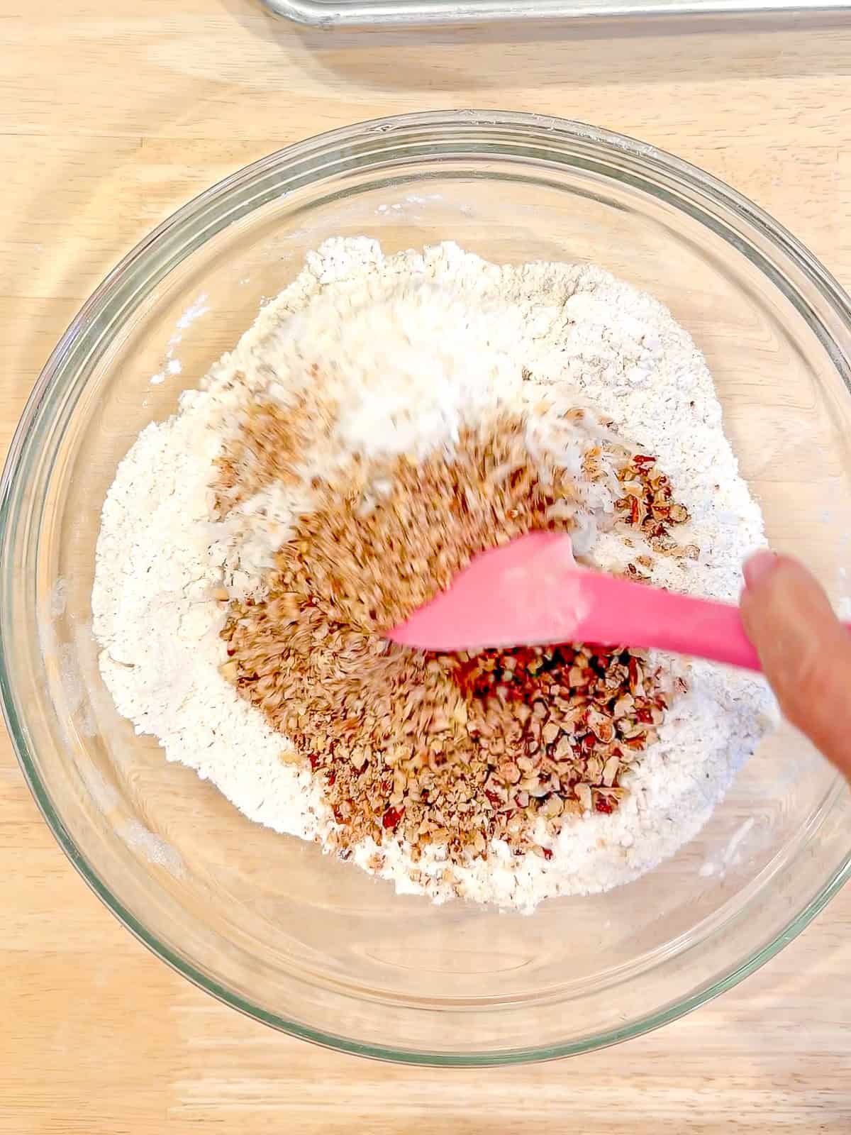 Mixing dry ingredients in a glass bowl.