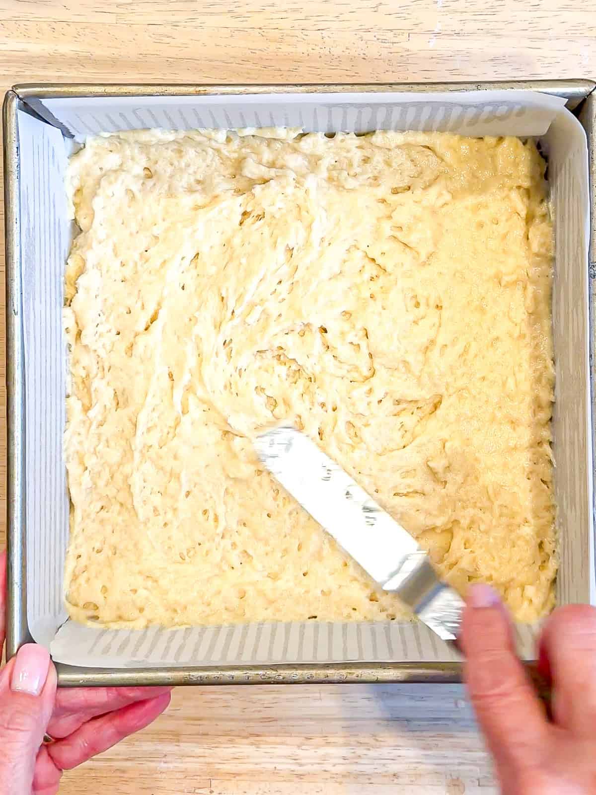 Spreading cake batter in a pan.