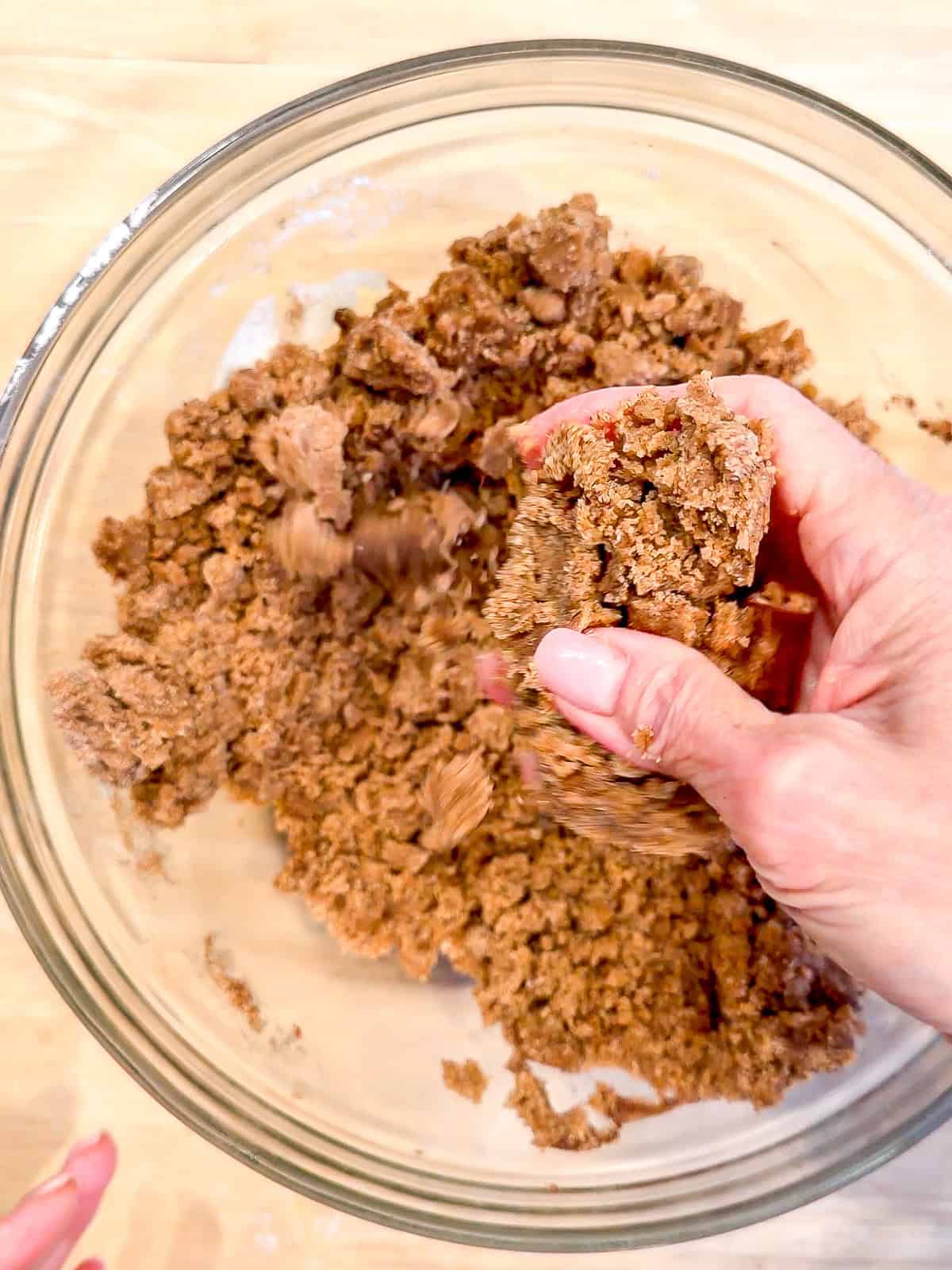 Mixing crumb topping in a glass bowl.