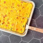 Sheet pan Denver omelette with a wooden spatula.
