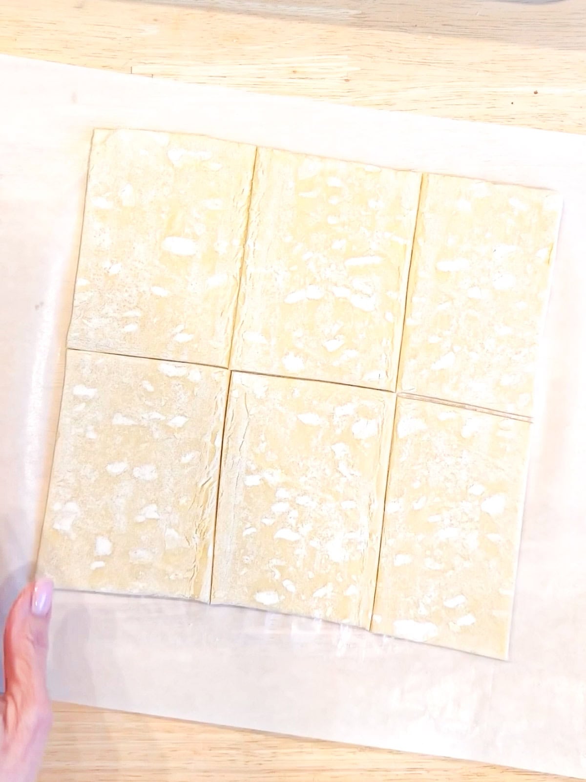 Cutting puff pastry into six pieces.