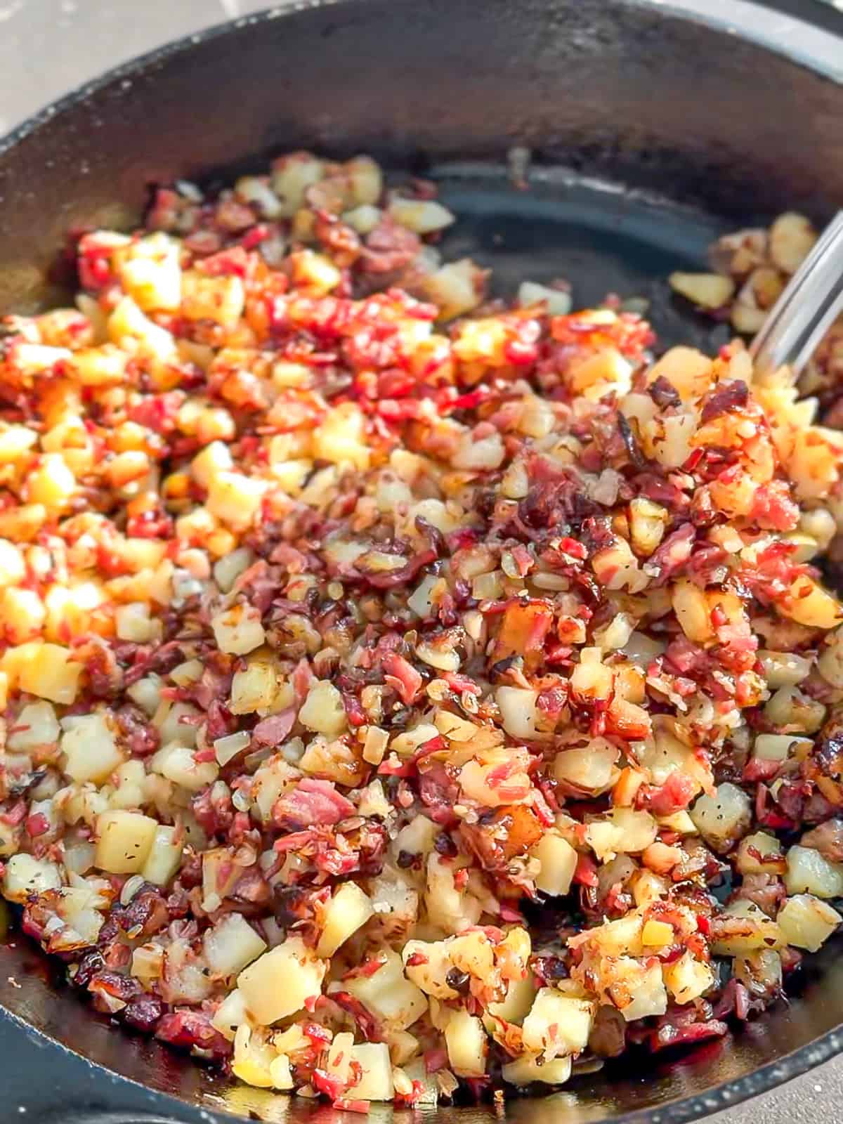 Corned beef hash in a cast-iron skillet.