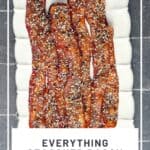 Pinterest image of everything seasoning candied bacon on a white plate.