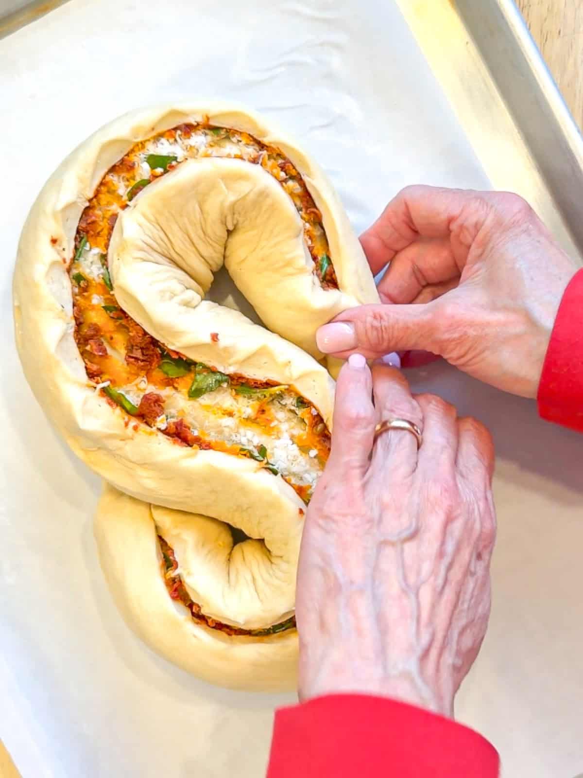 Tucking the ends of a loaf of bread underneath itself.