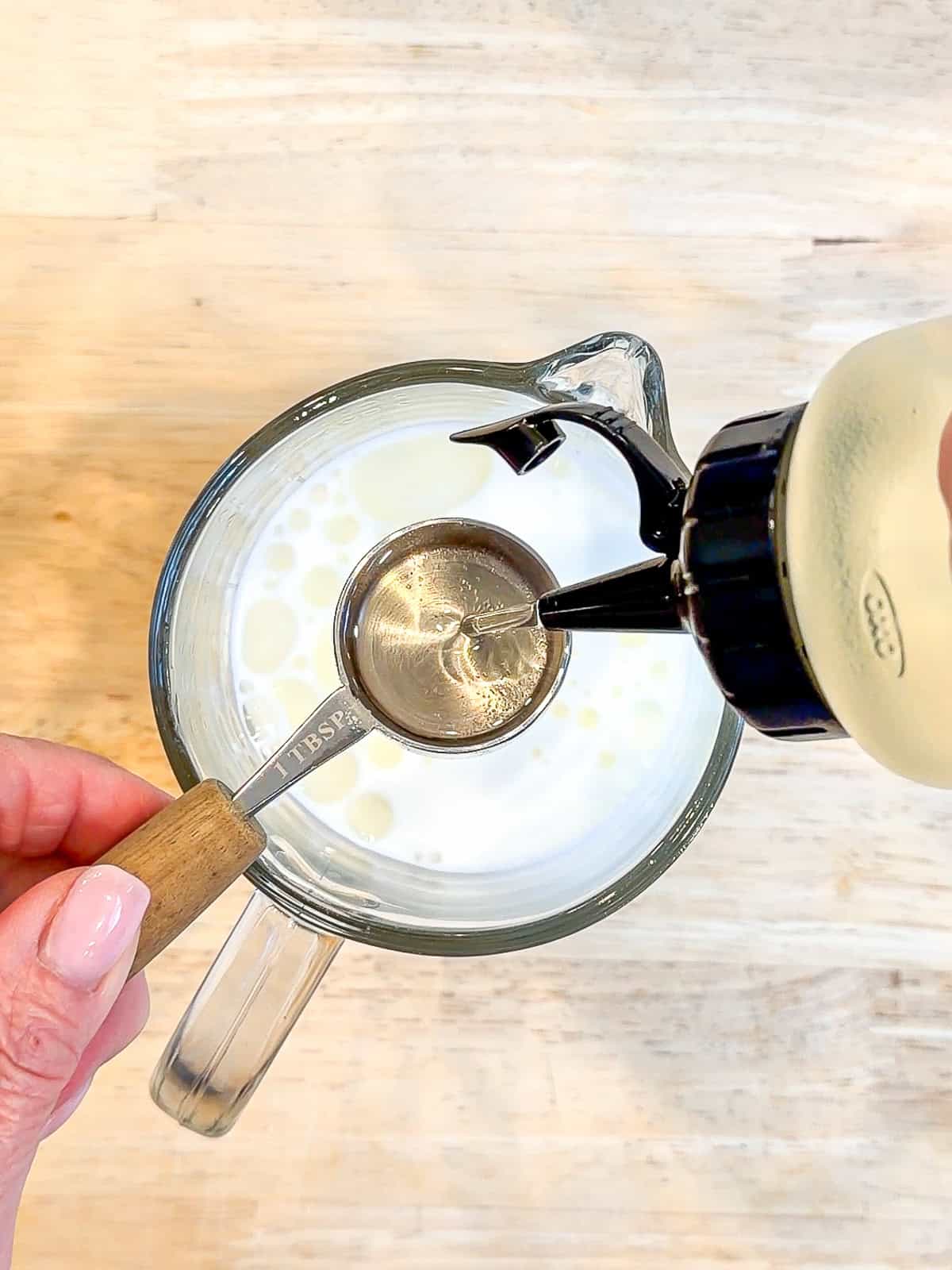 Adding vegetable oil into a glass measuring cup.