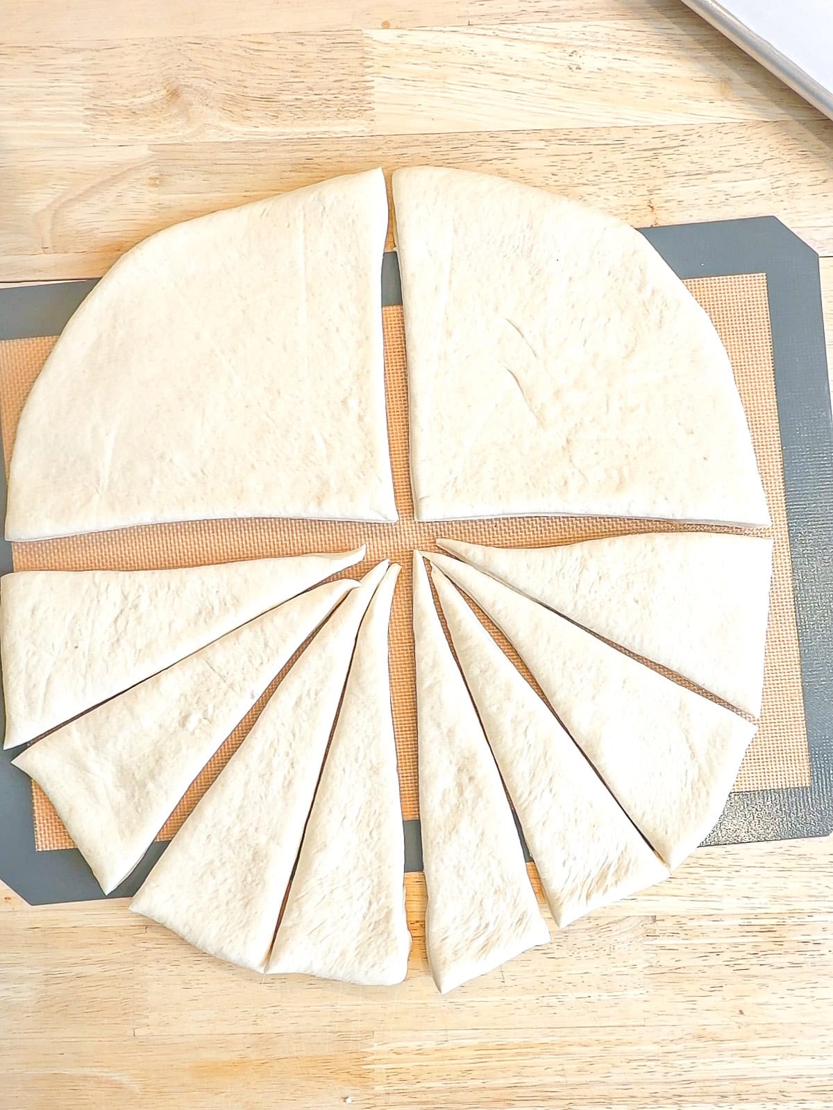 A circle of dough cut into triangular pieces.