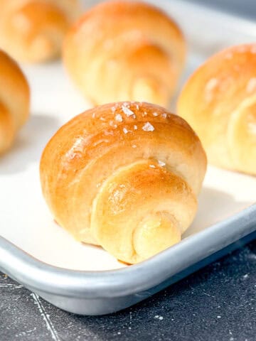 Crescent rolls on a parchment paper lined sheet pan.