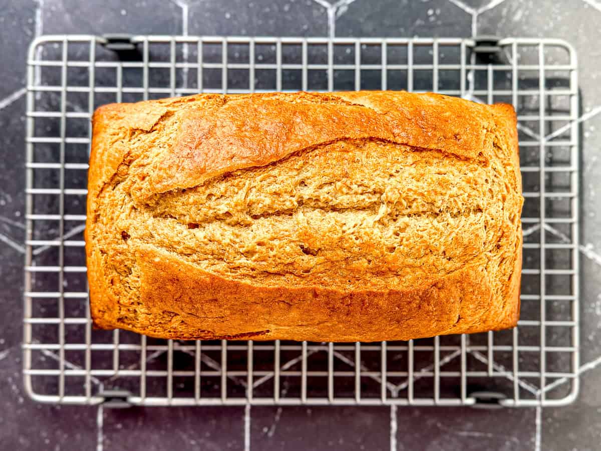 One bulb banana bread cooling on a wire rack.