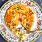 Bacon and spinach soufflé wrapped in puff pastry on a pink floral plate.