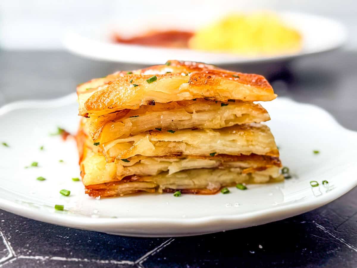 Stacks of sheet pan pommes anna on a white plate.