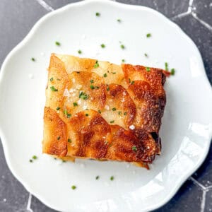 A slice of pommes anna on a white plate.
