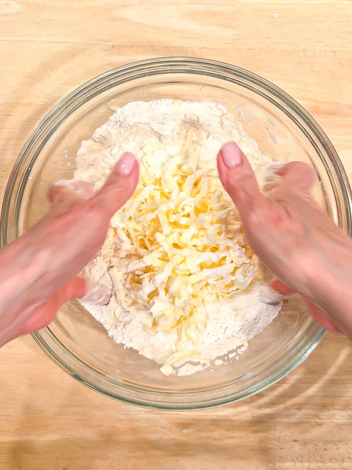 Mixing dry ingredients and butter in a glass bowl.