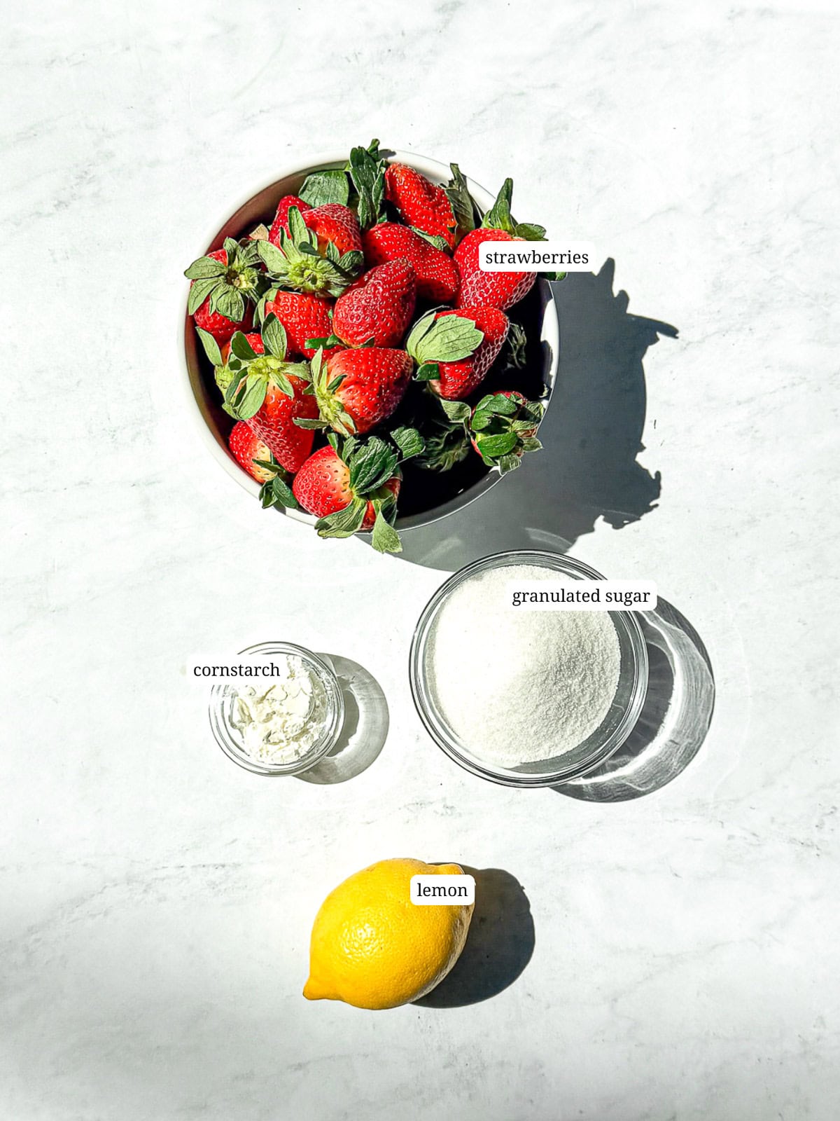Ingredients needed to make easy strawberry jam.