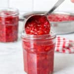 Ladling fresh strawberry jam into jars.