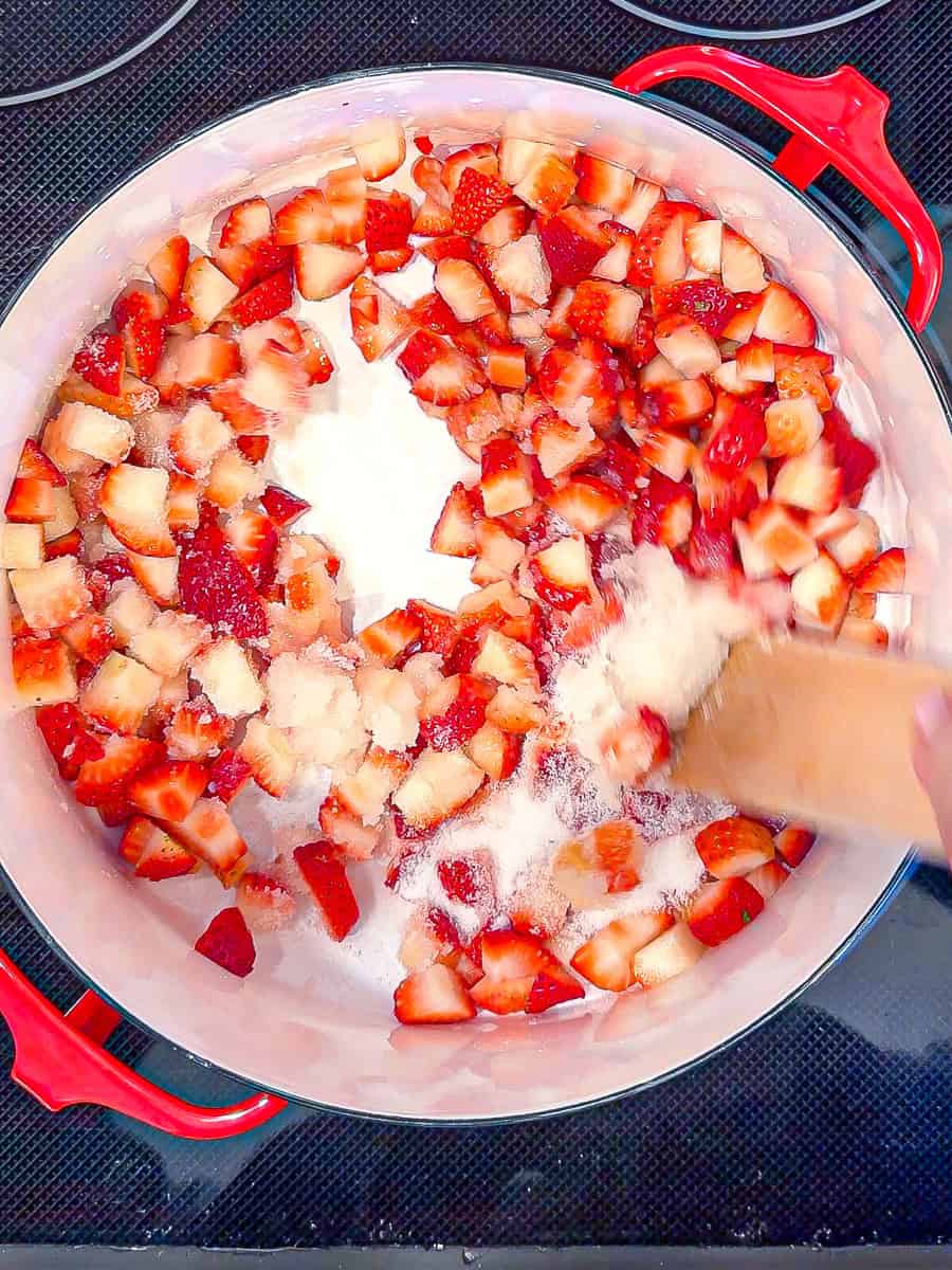 Simmering lemon juice, sugar, added diced strawberries in a large pan.