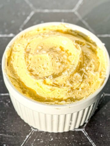 A ramekin filled with whipped salted butter with flaky salt on top.