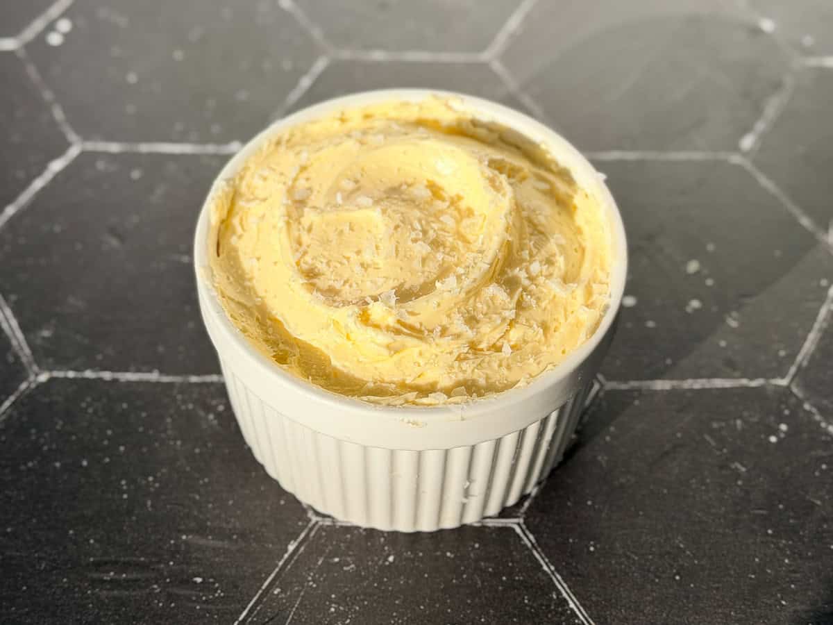 A ramekin filled with whipped salted butter with flaky salt on top.