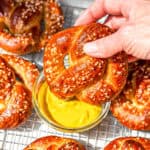 Dipping a pretzel into mustard.