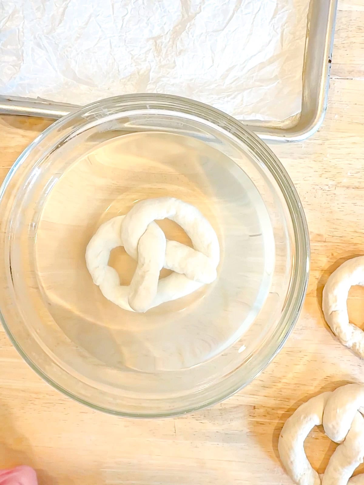 Dipping shaped pretzels into a cool baking soda bath.