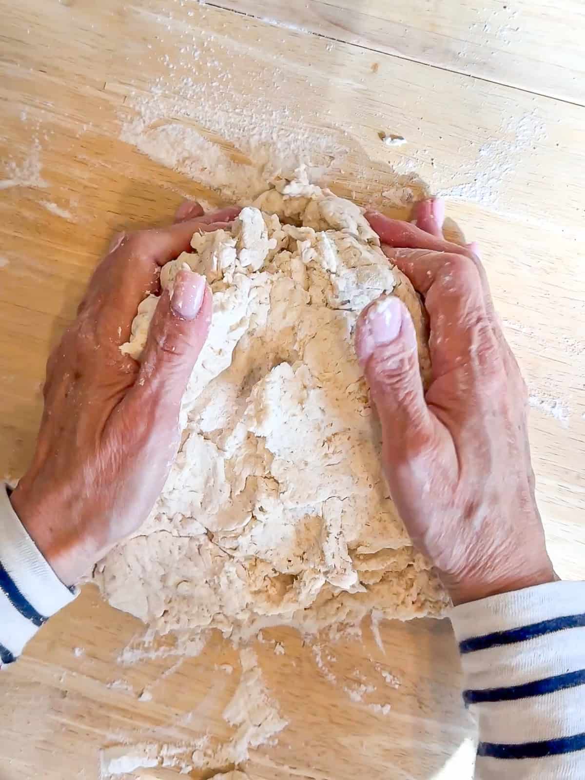 Shaping dough with my hands on a wooden counter.