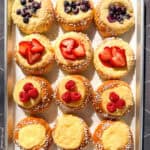 Berry topped brioche danishes on a parchment paper lined sheet pan.