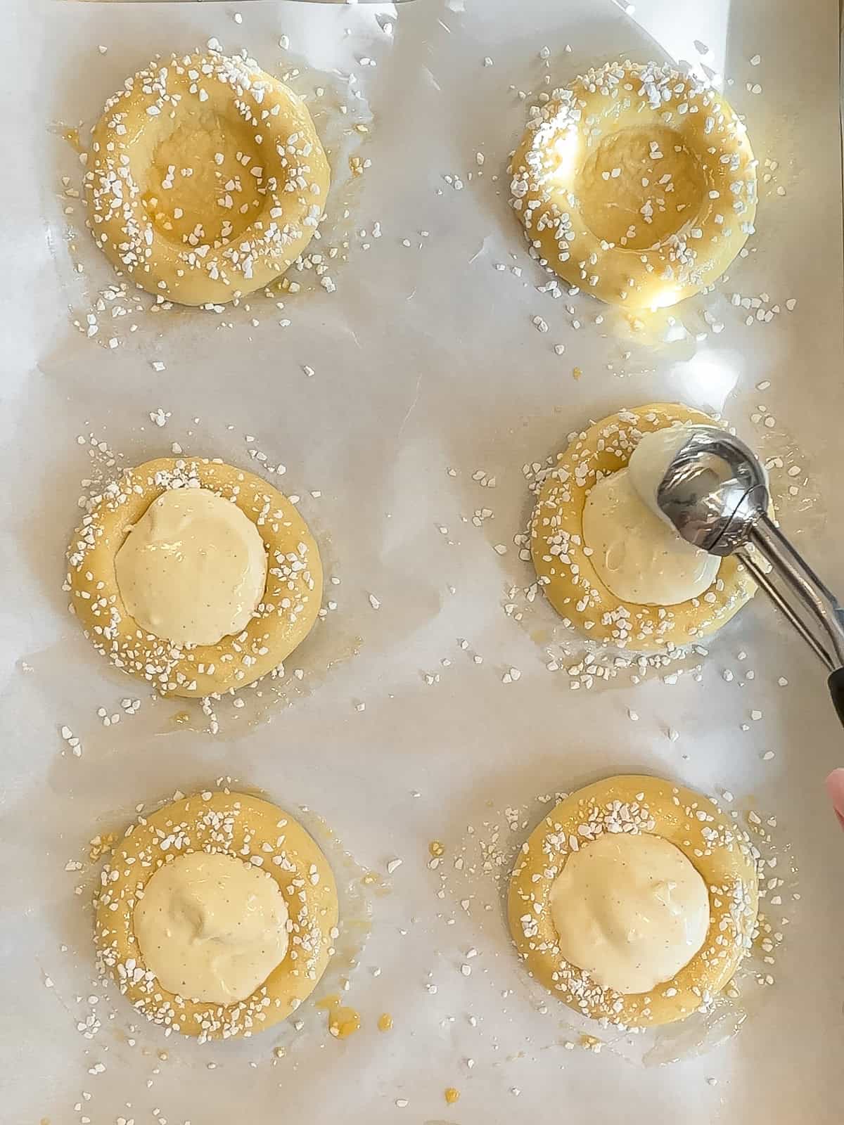 Scooping cream mixture into the center of brioche discs.