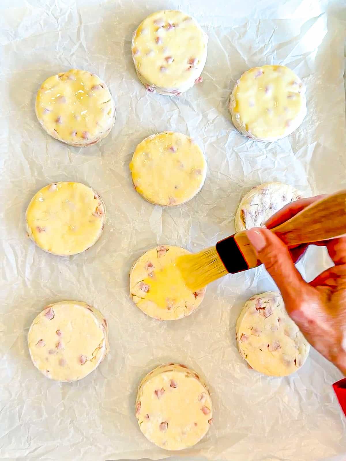 Brushing biscuits with an egg wash.