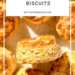 Pinterest image of a ham and cheese biscuit on parchment paper.