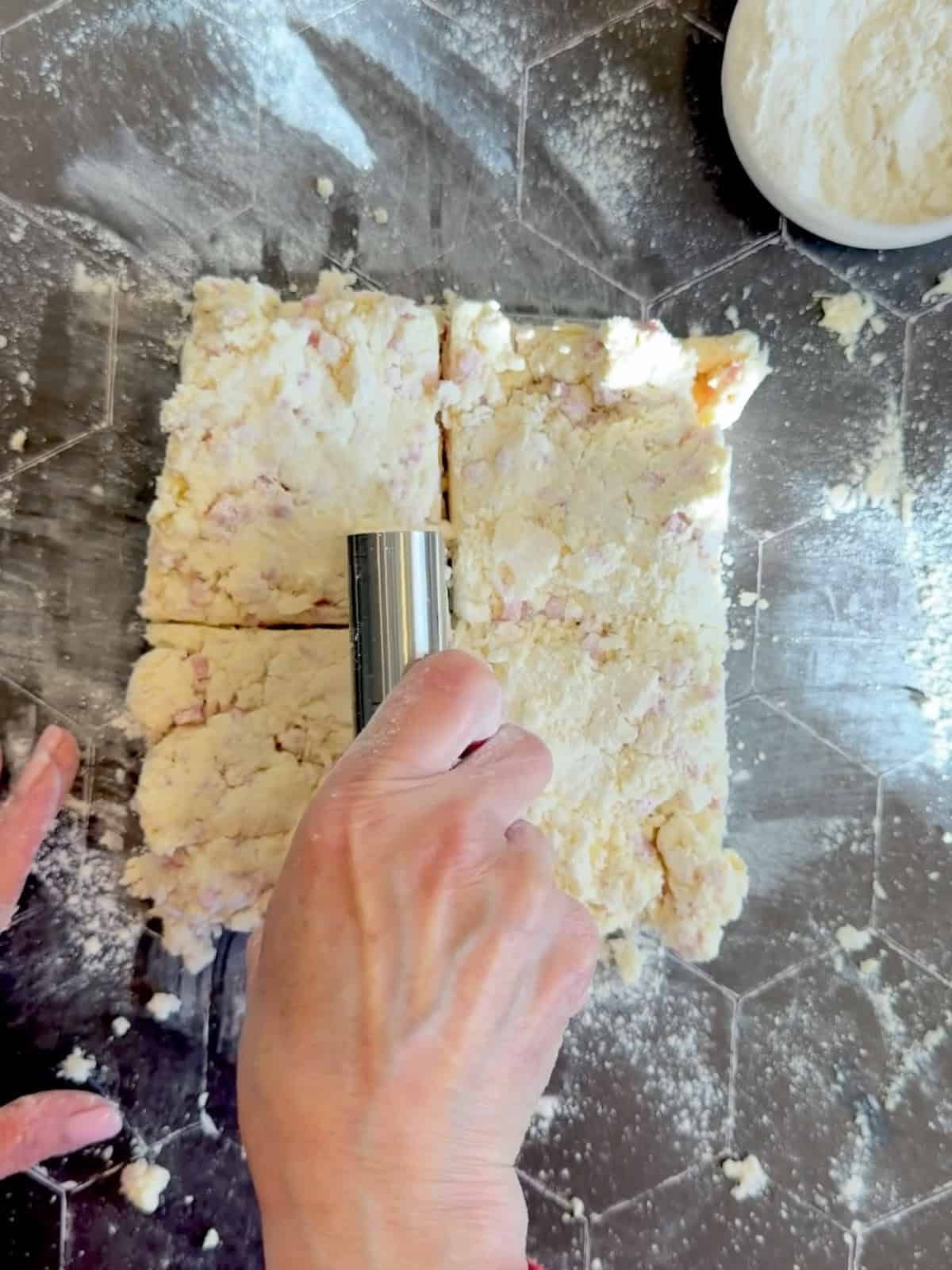 Cutting biscuit dough into four pieces.