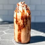 Mocha Frappuccino on a black counter with a subway tile backdrop.