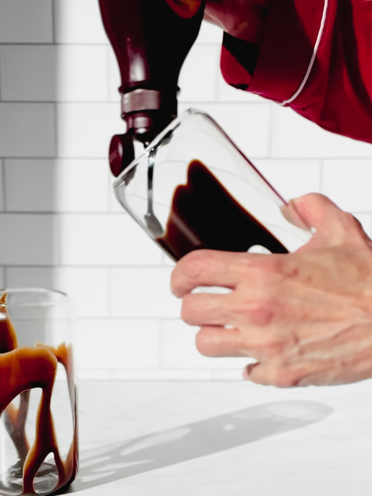 Drizzling chocolate syrup on the inside of a glass.