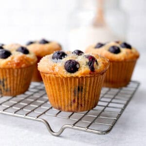 Blueberry pancake muffins on a wire rack.