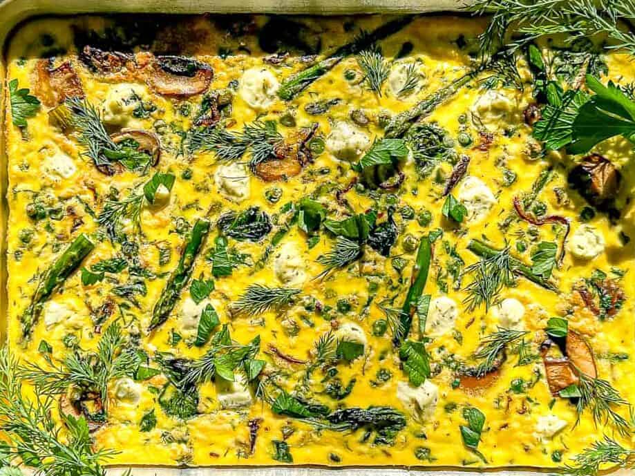 Image of a spring asparagus frittata in a sheet pan.