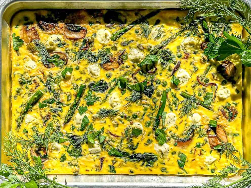 Image of a spring asparagus frittata in a sheet pan.